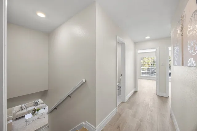 a view of hallway with furniture and wooden floor