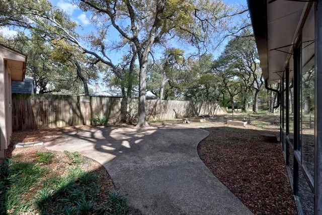 a view of a backyard with large trees