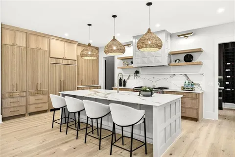 a kitchen with stainless steel appliances granite countertop a table and chairs in it
