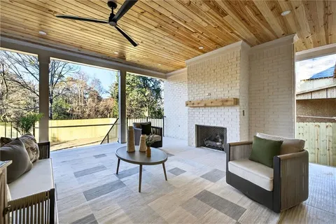 a living room with furniture a fireplace and a large window