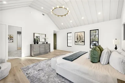 a bedroom with a large bed and a chandelier