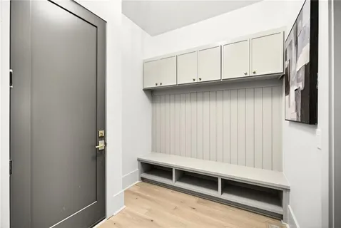 a living room with granite countertop a stove a sink and a large mirror with wooden floor