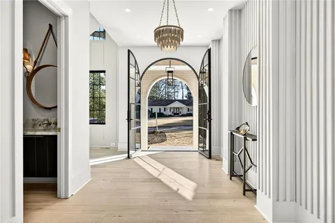 a kitchen with stainless steel appliances granite countertop a sink a refrigerator and chairs