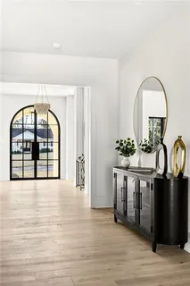 a kitchen with stainless steel appliances a stove a sink dishwasher and white cabinets with wooden floor