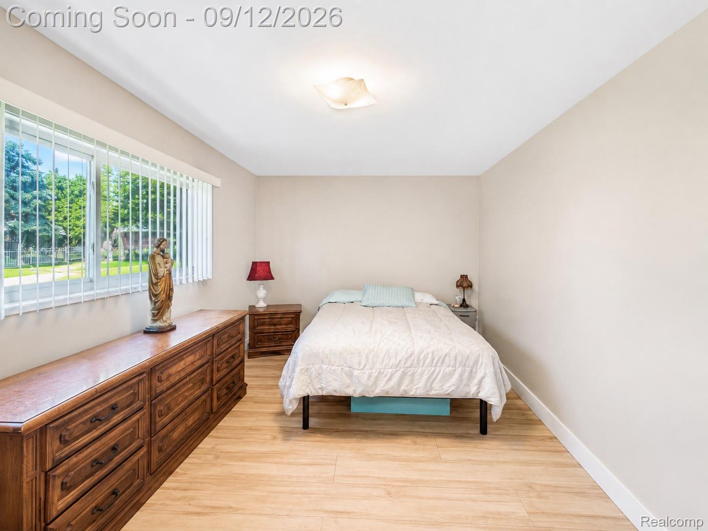 34398 Greentrees Road Sterling Heights, MI 48312 - Photo 12 of 36 Wood-finish flooring, neutral wall tones, window with vertical blinds, and a ceiling-mounted light fixture