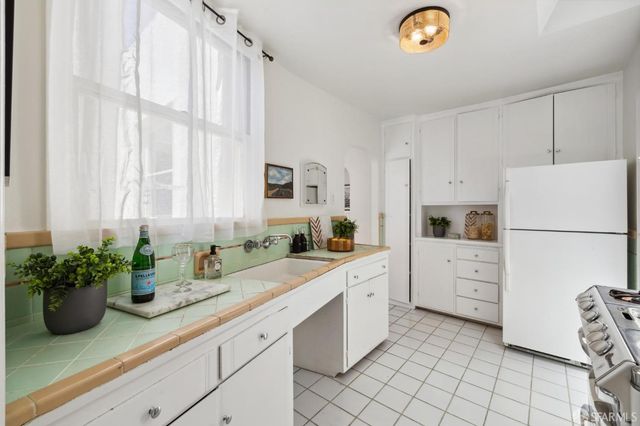 a kitchen with white cabinets and white appliances
