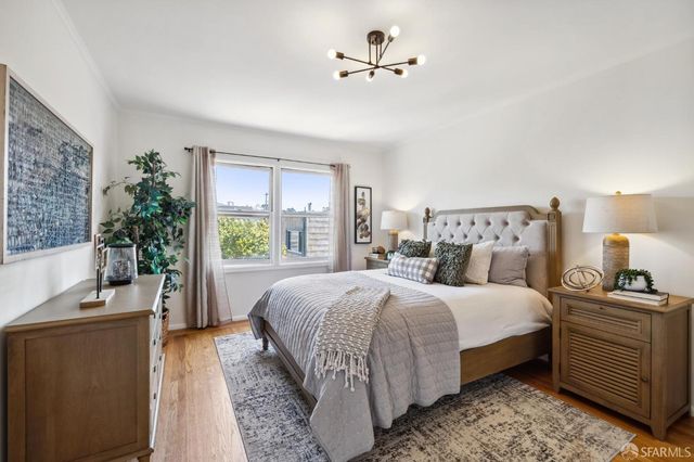 a bedroom with a large bed and a chandelier