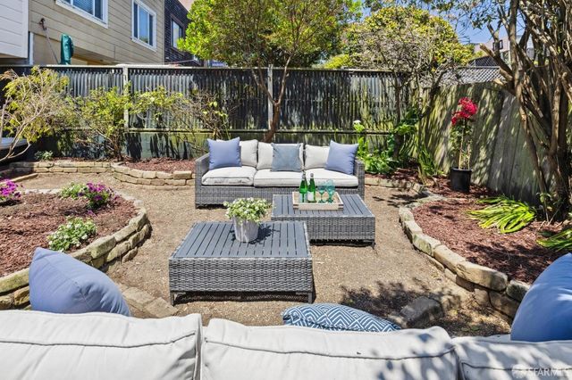 a view of yard with outdoor seating and lots of trees