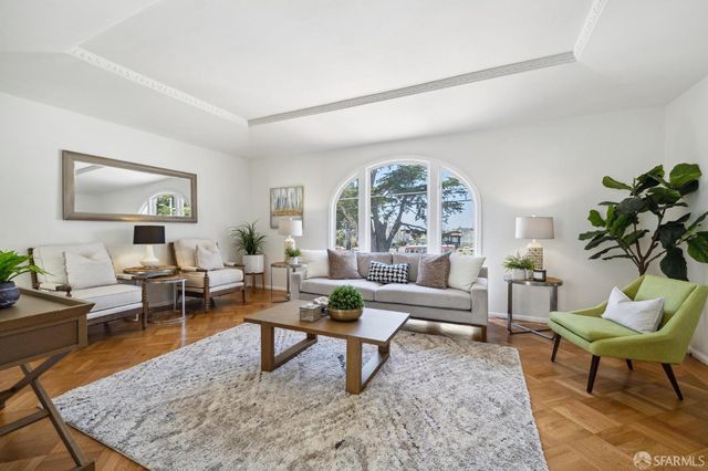 a living room with furniture potted plant and a large window