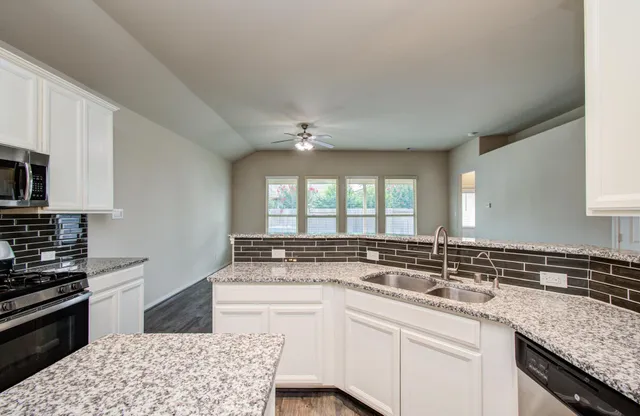 a kitchen with a sink stove and cabinets