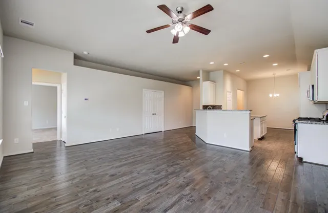 a view of a kitchen with wooden floor and a ceiling fan