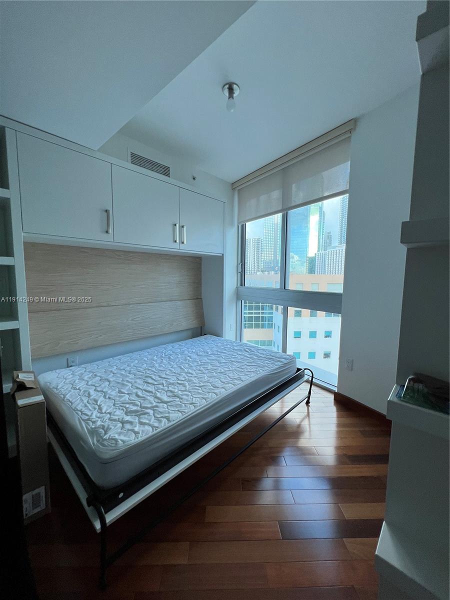 350 South Miami Avenue, Unit 1502 Miami, FL 33130 - Photo 11 of 30 a kitchen with kitchen island a counter top space and a wooden floor