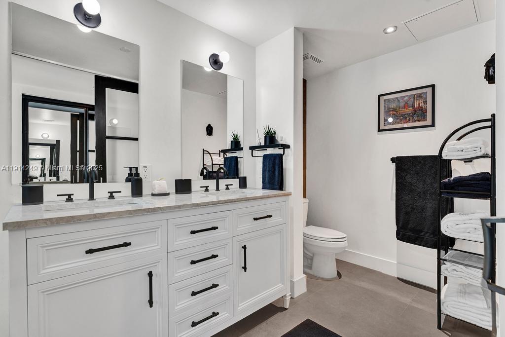 350 South Miami Avenue, Unit 1502 Miami, FL 33130 - Photo 14 of 30 a bathroom with a double vanity sink a toilet and a mirror