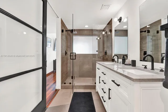 a bathroom with a double vanity sink mirror double and shower