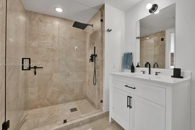 a bathroom with a shower sink vanity and mirror