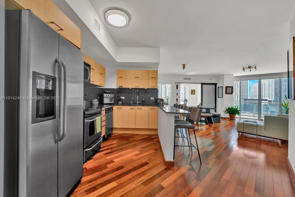 350 South Miami Avenue, Unit 1502 Miami, FL 33130 - Photo 2 of 30 a kitchen with stainless steel appliances granite countertop a refrigerator a stove and a wooden floors