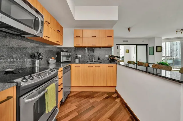 a kitchen with stainless steel appliances granite countertop a stove a sink and a microwave