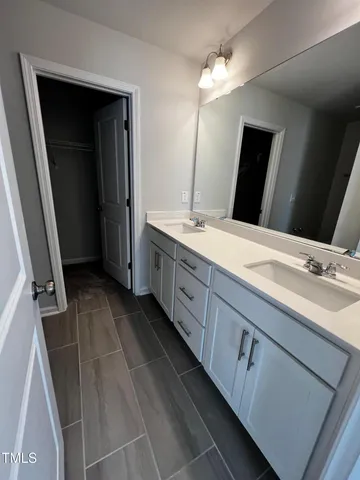 a bathroom with a double vanity sink and a mirror