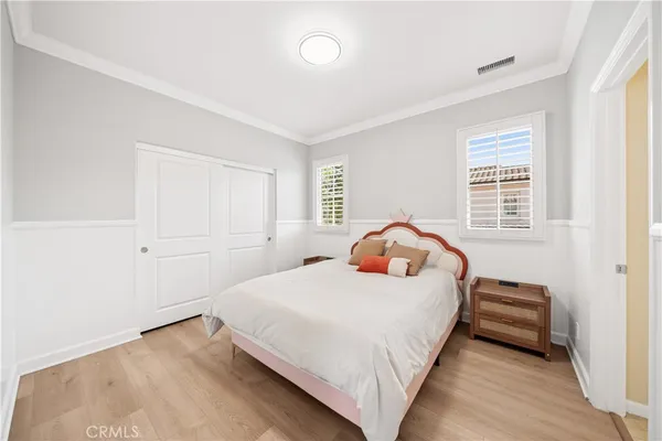 a view of a hallway with wooden floor and a bathroom