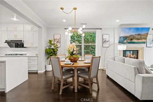 a dining room with furniture a floor to ceiling window and kitchen view