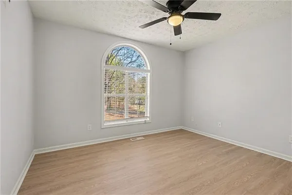 an empty room with a window and a fan