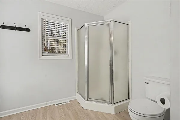 a bathroom with a toilet and a shower