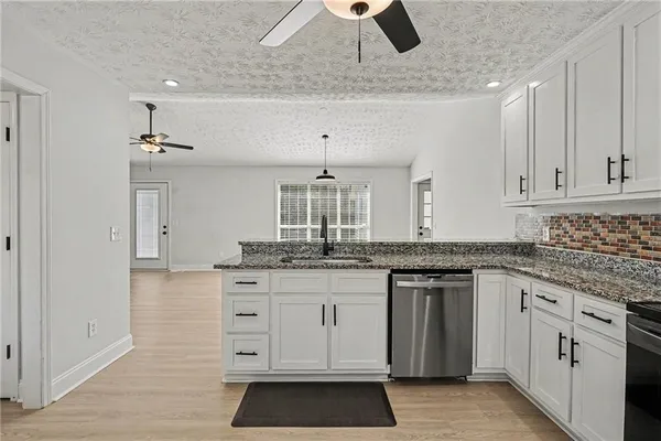 a kitchen with granite countertop white cabinets and white appliances