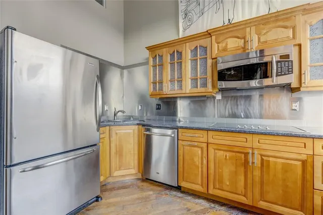 a kitchen with stainless steel appliances granite countertop a refrigerator a microwave and stove