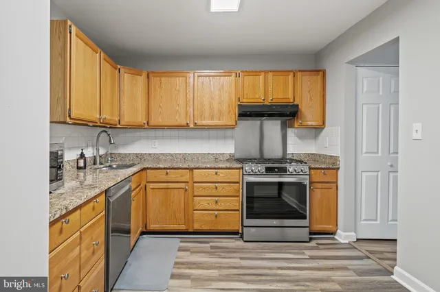 a kitchen with stainless steel appliances granite countertop a stove and cabinets