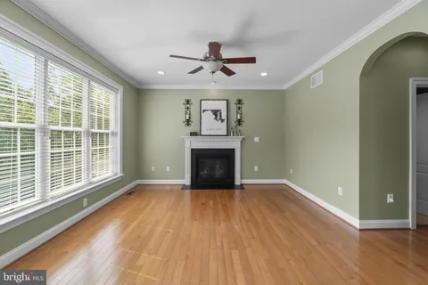 a bedroom with a bed and a large window with wooden floor