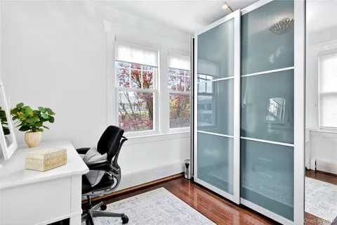 a view of a workspace with furniture and a window