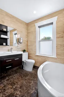 a bathroom with a bathtub sink and mirror