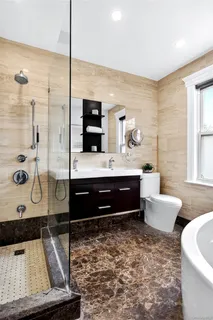 a bathroom with a double vanity sink a toilet and shower