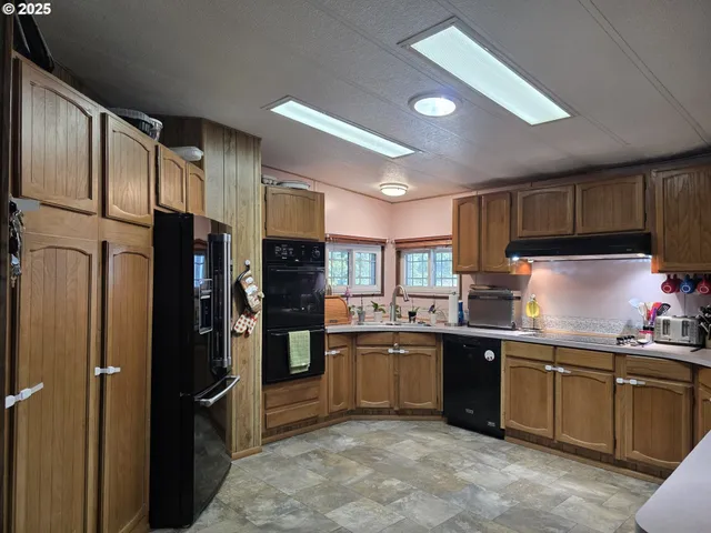 a kitchen with stainless steel appliances granite countertop a stove refrigerator sink and cabinets