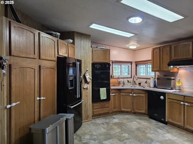 a kitchen with stainless steel appliances granite countertop a refrigerator and a sink