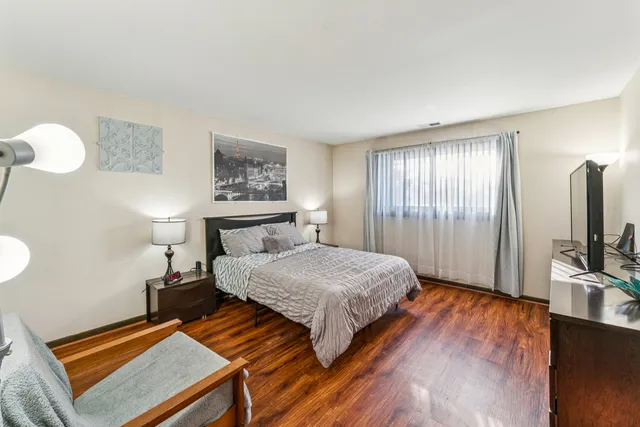 a bedroom with a bed and a flat tv screen on a dresser