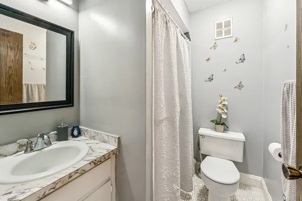 a bathroom with a granite countertop sink a toilet and a mirror