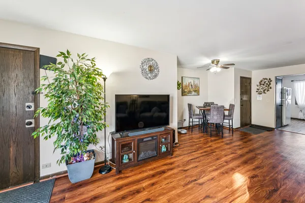 a living room with furniture potted plant and flat screen tv