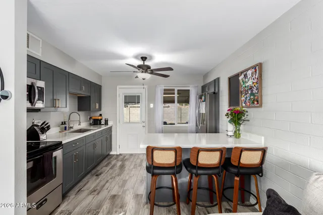 a kitchen with stainless steel appliances a stove a sink and a refrigerator