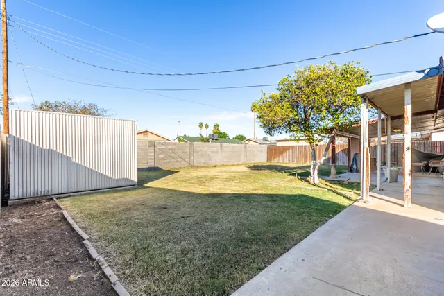 a view of a house with a backyard and a tree