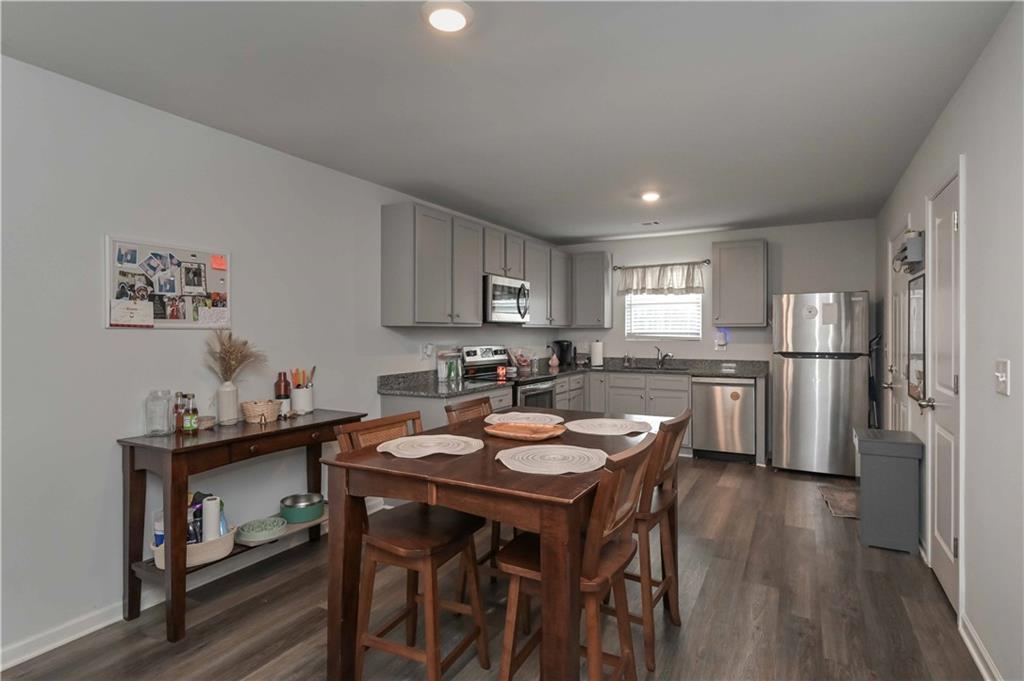 294 Muskogee Drive Dallas, GA 30132 - Photo 14 of 32 a kitchen with a dining table chairs and refrigerator