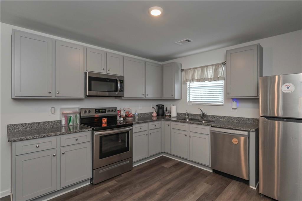 294 Muskogee Drive Dallas, GA 30132 - Photo 17 of 32 a kitchen with granite countertop white cabinets and white appliances