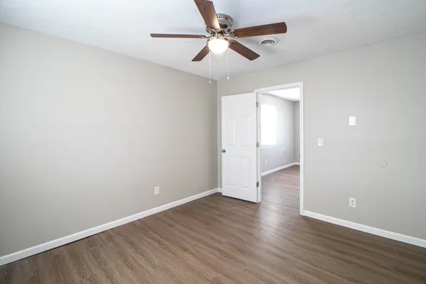 wooden floor in an empty room with a fan