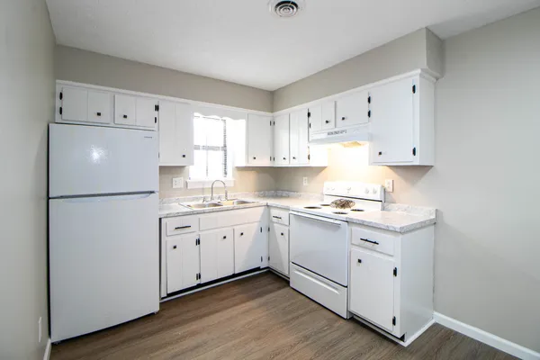 a kitchen with granite countertop white cabinets and white appliances