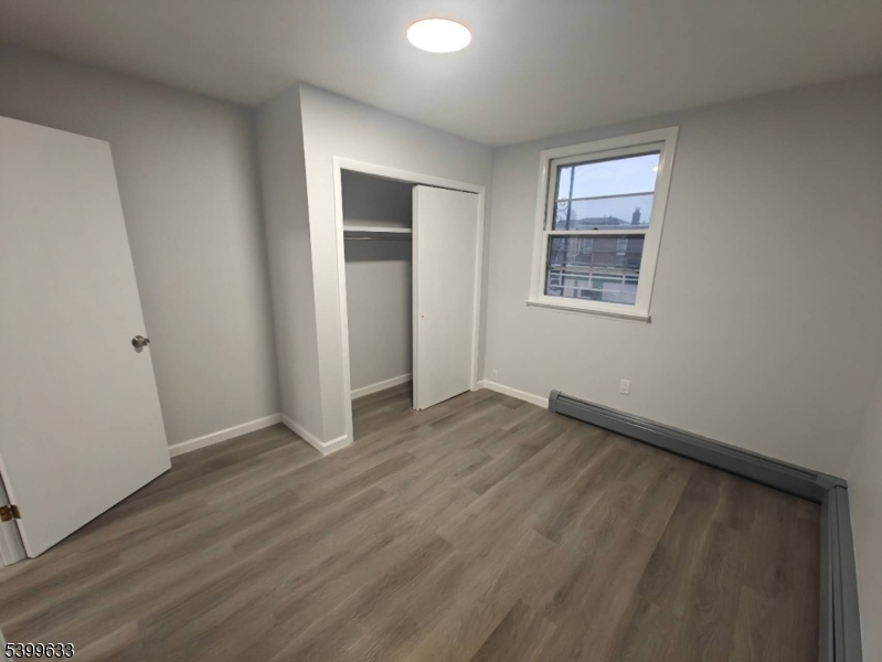 327 Christine Street, Unit 2L Elizabeth, NJ 07202 - Photo 6 of 11 an empty room with wooden floor and windows