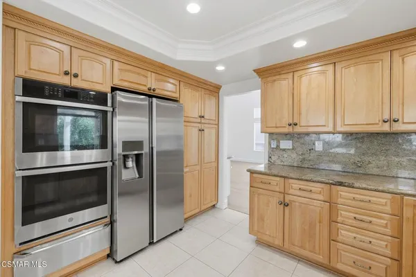 a kitchen with granite countertop cabinets stainless steel appliances and a counter space