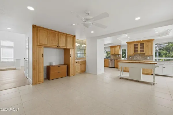 a large kitchen with stainless steel appliances kitchen island granite countertop a refrigerator and cabinets