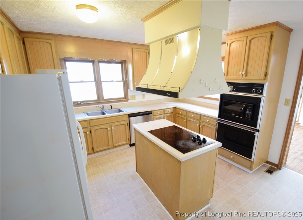 2347 Rolling Hill Road Fayetteville, NC 28304 - Photo 11 of 26 a kitchen that has a sink a stove top oven a refrigerator and a window