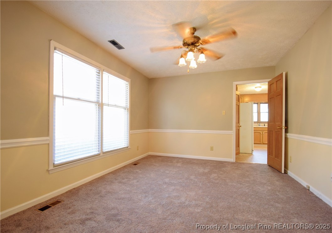 2347 Rolling Hill Road Fayetteville, NC 28304 - Photo 4 of 26 an empty room with windows and chandelier fan