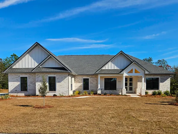 a front view of a house with a garden and yard